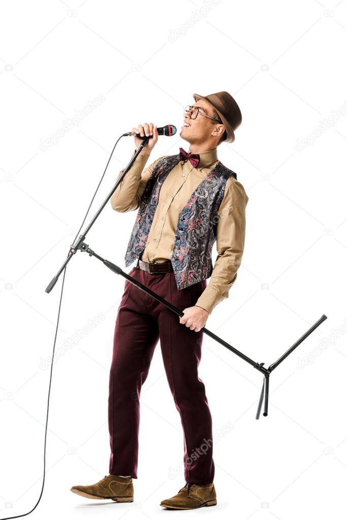 young emotional mixed race male musician holding microphone and singing isolated on white
