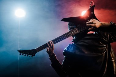 arkadan görünüşü elektro gitar başının arkasında sahne alanı'nda oynamaya deri ceketli erkek müzisyen 