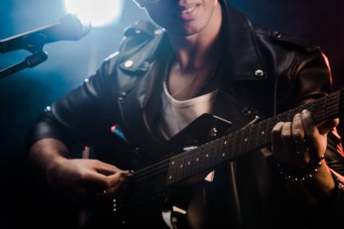 mikrofon şarkı ve elektrik gitar rock konseri sırasında sahne alanı'nda oynamak erkek müzisyen kısmi görünümü 