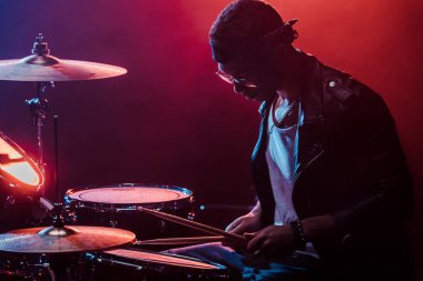 karışık ırk sahnede rock konseri sırasında davul çalmaya deri ceketli erkek müzisyen  