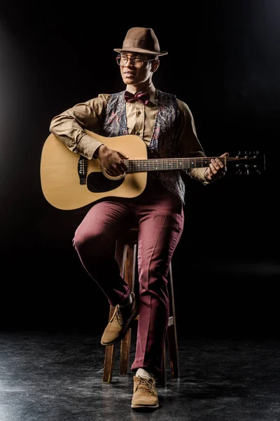 Hombre Con Sombrero Elegante Tocando Guitarra Acústica Mientras Está Sentado — Foto de stock gratis