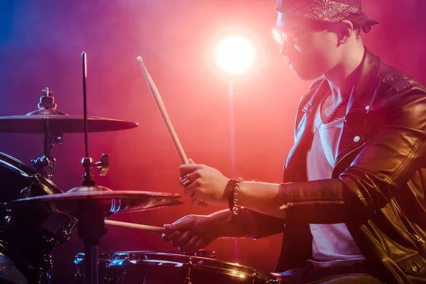 ステージでのロック コンサート中にドラム レザー ジャケットで若い男性ミュージシャンの側面図 — ストック写真
