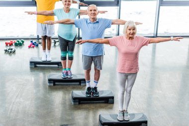 üst düzey sporcuların spor salonunda adım platformlarda egzersiz zaman uyumlu yüksek açılı görünüş