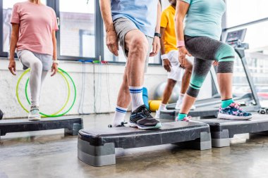 üst düzey sporcular spor salonunda adım platformlarda zaman uyumlu antreman atış kırpılmış