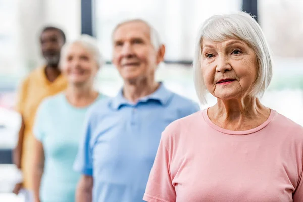 multicultural senior sportspeople sanding at gym