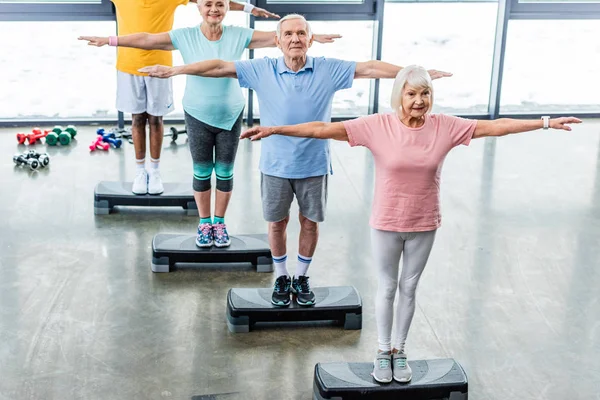 Hoge Hoekmening Van Senior Atleten Synchrone Uitoefenen Stap Platforms Sporthal — Stockfoto