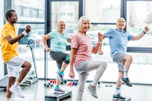 Selective Focus Multiethnic Senior Athletes Synchronous Exercising Step Platforms Gym — Stock Photo, Image