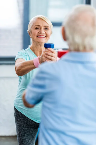 Vrolijke Senior Vrouw Doen Oefening Met Dumbbell Voor Haar Echtgenoot — Stockfoto