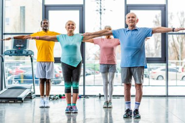 çok ırklı üst düzey sporcular spor salonunda egzersiz yaparak zaman uyumlu
