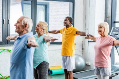 seçici odak çok ırklı üst düzey sporcuların spor salonunda egzersiz yaparak zaman uyumlu