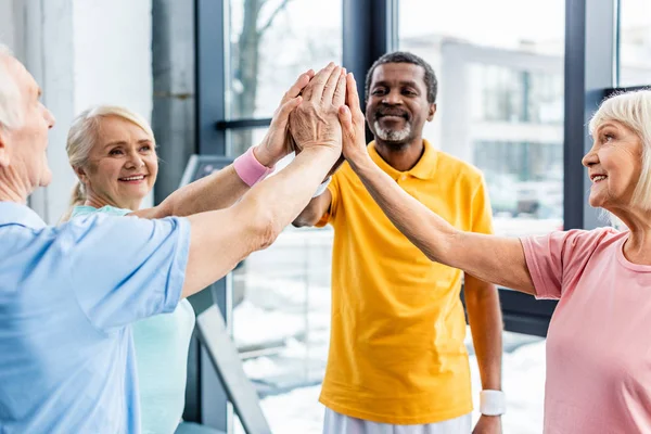 Fröhliche Multikulturelle Senioren Legen Turnhalle Hand — Stockfoto