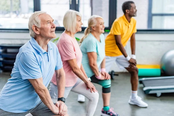 Selective Focus Senior Multiethnic Sportspeople Synchronous Stretching Sports Hall — Stock Photo, Image