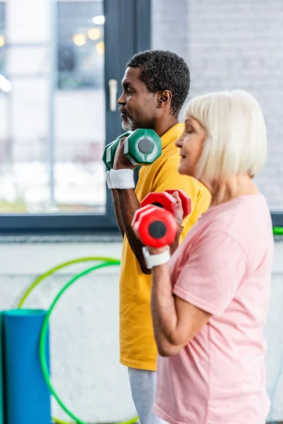 Spor Salonunda Dumbbells Ile Egzersiz Yaparak Interracial Olgun Çift Yan — Stok fotoğraf