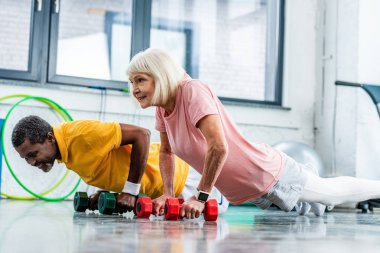 itme yapıyor Interracial Olgun çift ups spor salonunda dumbbells ile