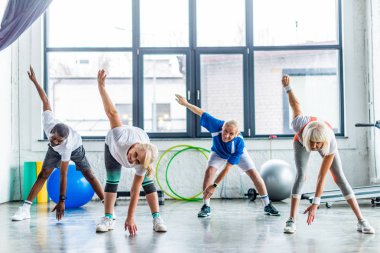 çok ırklı üst düzey sporcu zaman uyumlu spor salonunda egzersiz gülümseyen
