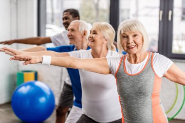 mutlu üst düzey çok ırklı sporcu spor salonunda egzersiz zaman uyumlu