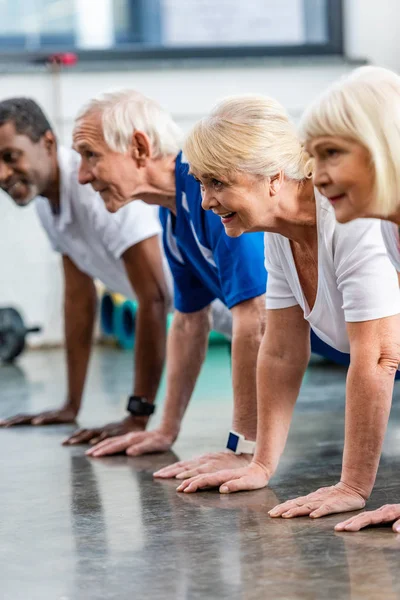 Lachende Mutiethnic Senior Atleten Doen Plank Bij Sporthal — Stockfoto