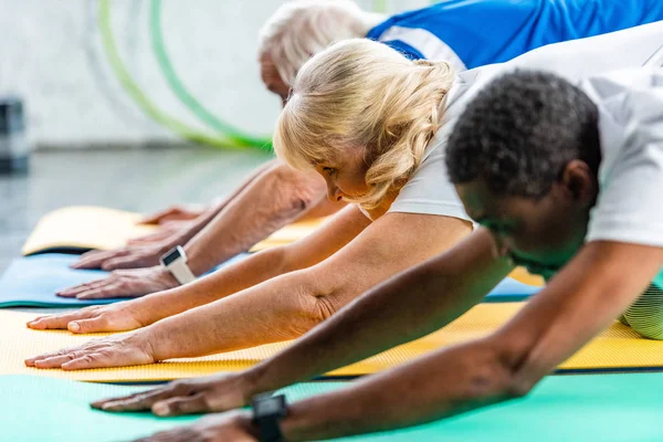 高级女运动员在健身房与朋友一起锻炼的选择性焦点 — 图库照片