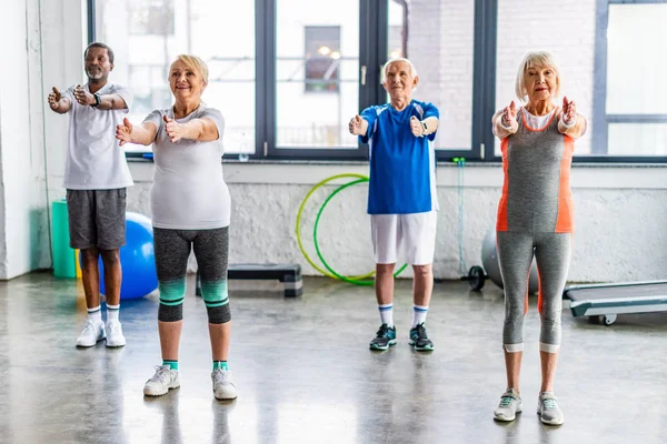 Desportistas Seniores Multiétnicos Alegres Exercício Síncrono Salão Esportes — Fotografia de Stock