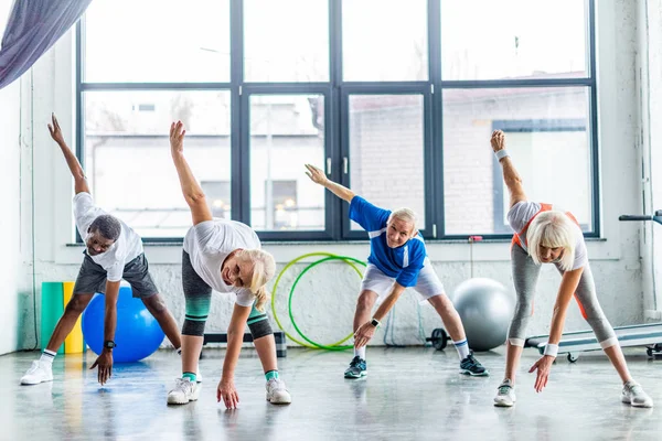 Smiling Multiethnic Senior Sportspeople Synchronous Exercising Sports Hall — Stock Photo, Image