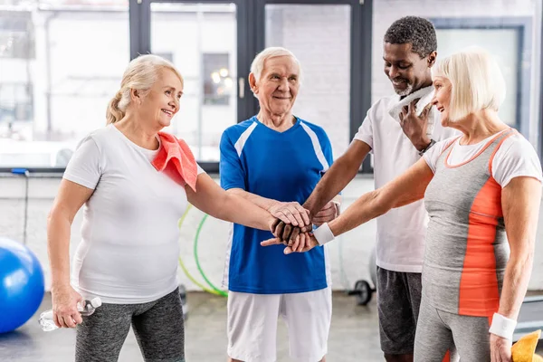 Sonriente Sénior Multiculutral Amigos Poniendo Manos Juntas Sala Deportes — Foto de Stock