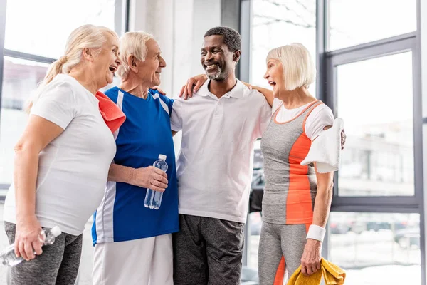 Lachende Multikulturelle Senioren Die Sich Fitnessstudio Unterhalten Und Umarmen — Stockfoto