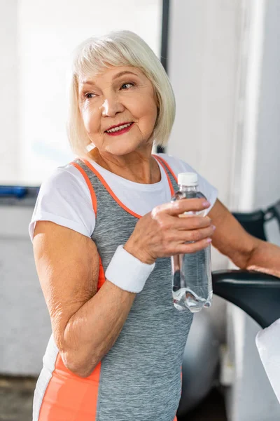 Selektiv Fokus För Glada Senior Idrottskvinna Hålla Flaska Vatten Och — Stockfoto