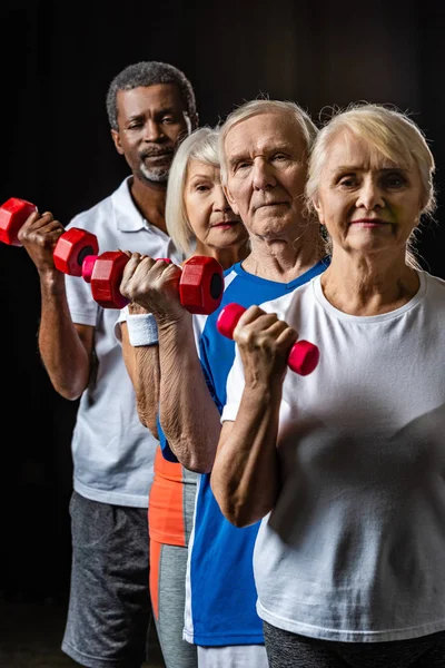 Deportistas Senior Multiculturales Haciendo Ejercicio Con Pesas Sobre Negro — Foto de Stock