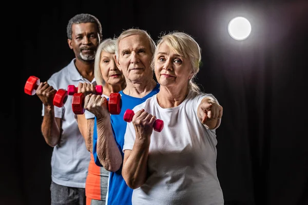 Senior Sportswoman Dumbbell Pointing Camera While Her Friends Standing Black — Stock Photo, Image