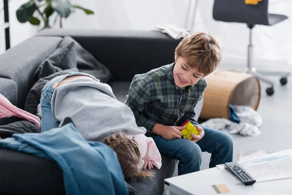 Entzückende Glückliche Geschwister Die Auf Der Couch Spielen Und Spaß — Stockfoto