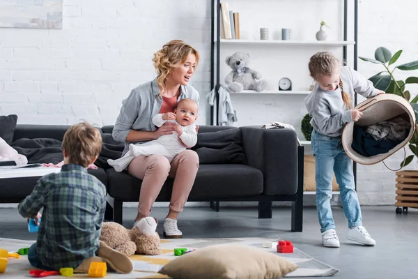 Exhausted Mother Infant Child Sitting Couch Looking Naughty Siblings Playing — Stock Photo, Image