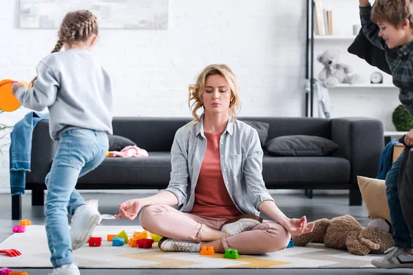 Mama Meditând Poziția Lotus Timp Copiii Obraznici Joacă Acasă — Fotografie, imagine de stoc