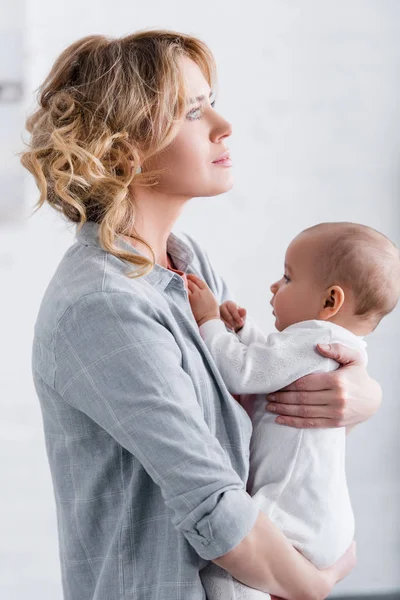 Side View Thoughtful Mother Holding Adorable Infant Child Looking Away — Stock Photo, Image