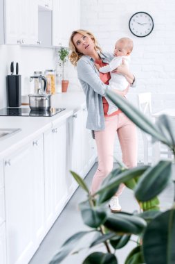 mutfakta yemek yaparken yorgun anne holding çok güzel bebek çocuk
