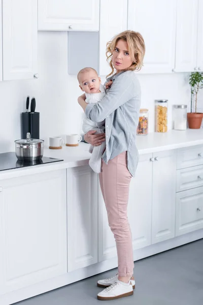 Mãe Cansada Segurando Bebê Infantil Olhando Para Câmera Cozinha — Fotografia de Stock