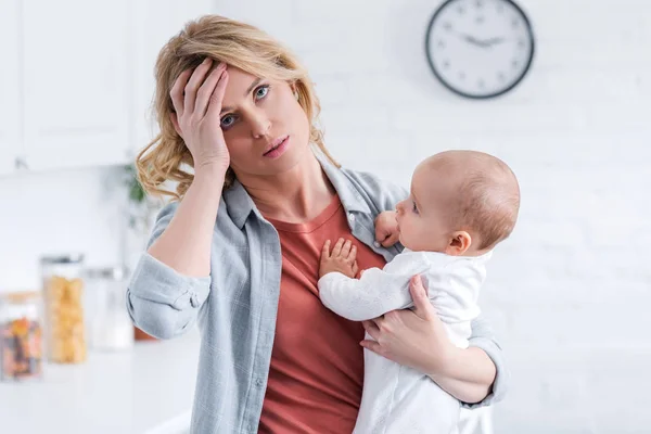 Tired Mother Holding Infant Baby Standing Hand Forehead Home — Stock Photo, Image