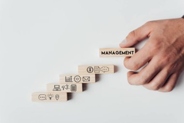 word ile ahşap blok 'beyaz izole Yönetimi' ahşap tuğla üstüne simgelerle tutan adam görünümünü kırpılmış