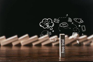 seçici odak kelime 'ücretsiz deneme' ve siyahta izole simgeleri ile ahşap tuğla