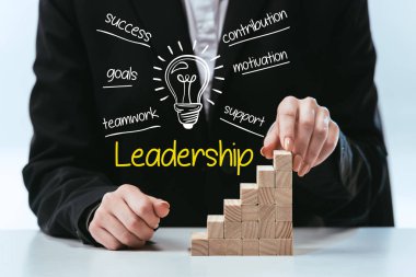 cropped view of woman with wooden career ladder, components of leadership on foreground clipart