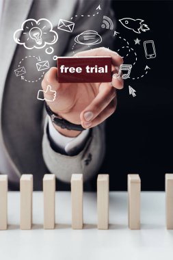 kırmızı tuğla ile 'siyah, ön plan simgeleri izole kelime ücretsiz deneme' tutan adamın kısmi görünümü