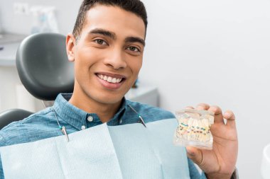 Afro-Amerikan yakışıklı diş çene modeli diş telleri ile tutarak