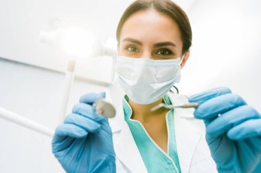 seçici odak Instuments elinde tutan kadın stomatologist