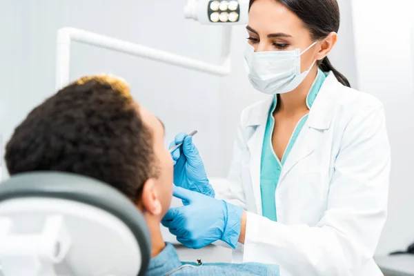Dentista Donna Maschera Esaminando Paziente Afro Americano — Foto Stock