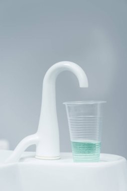 plastik kap sıvı yakınındaki beyaz dokunun içinde diş kliniği ile yakın çekim 