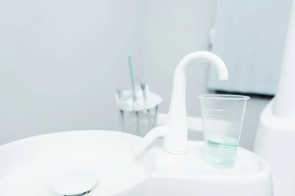 Закрытие Пластиковой Чашки Жидкостью Возле Крана Стоматологической Клинике — стоковое фото