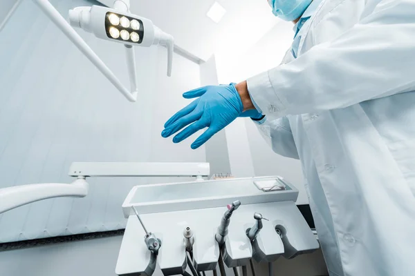 ラテックス手袋を身に着けている男性歯科医のビューをトリミング — ストック写真