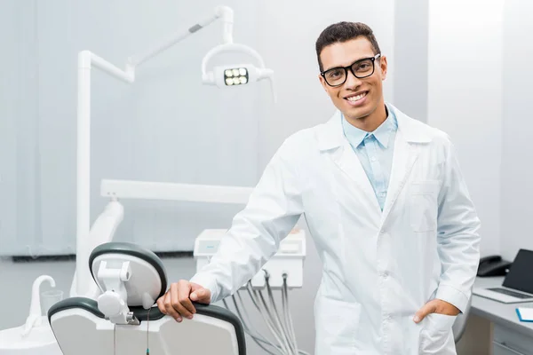 英俊的非洲裔美国牙医微笑着 手放在口袋里站着 — 图库照片