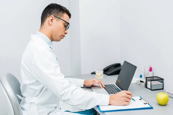 Handsome African American Doctor Making Notes Using Laptop — Stock Photo, Image