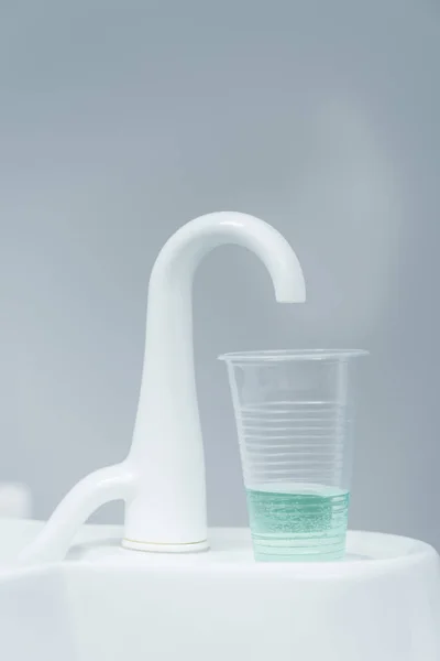 Nahaufnahme Eines Plastikbechers Mit Flüssigkeit Der Nähe Des Weißen Wasserhahns — Stockfoto