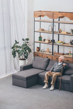 gri saçlı kanepede otururken yürüyüş baston holding emekli adam 